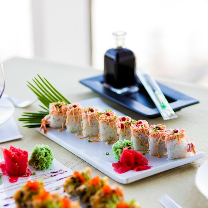 Elegant sushi platter featuring salmon, rice, and wasabi, served with soy sauce at a restaurant.